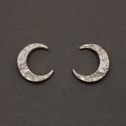 Crescent moon small stud earrings in sterling silver textured with impressions of granite